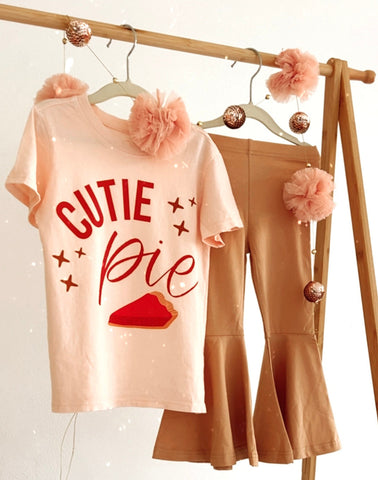 Kid Thanksgiving outfit 'CUTIE Pie' t-shirt and beige pants on a wooden rack.