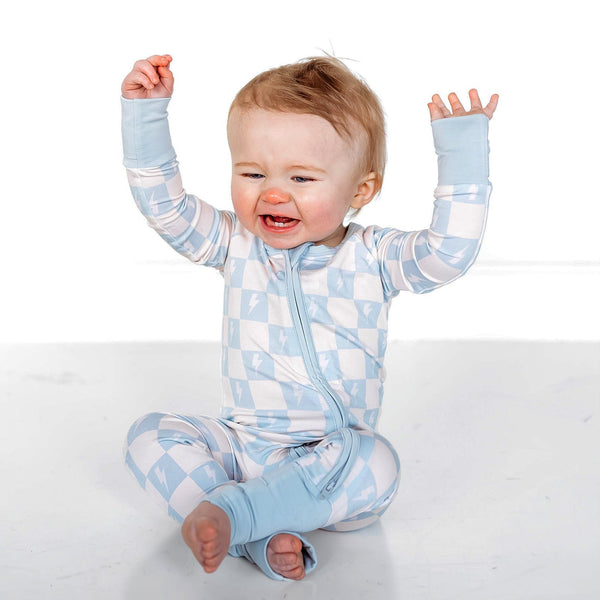 Baby wearing a blue and white checkered outfit on a white background